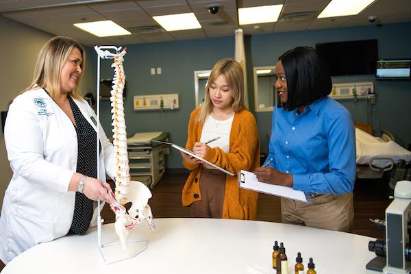 A nurse educator using a model to teach students.