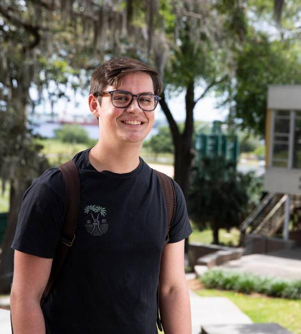 Jacksonville University Student smiling with campus in the background.