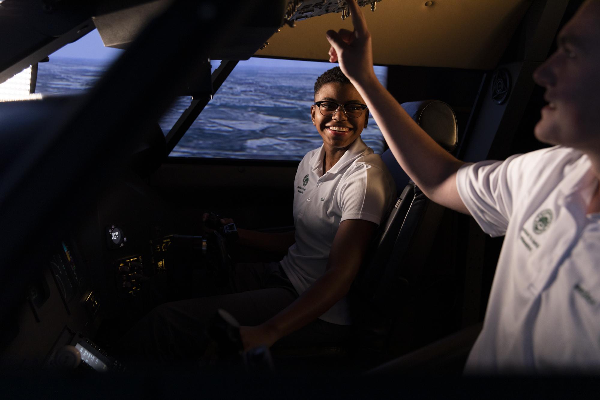 Two students in flight simulator.