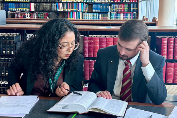 两个学生在法律图书馆一起阅读法律教科书.