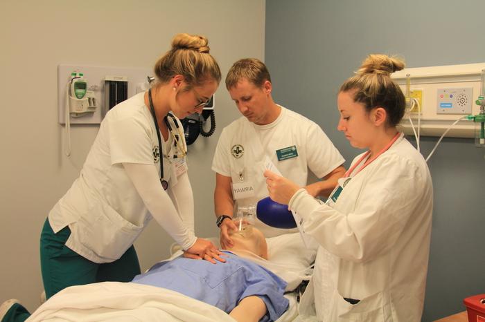 Three nursing students learning in the lab.