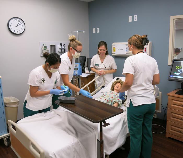 护理专业的学生在一个医疗模型上进行模拟.