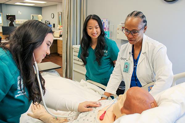 Three nursing students practicing in the Simulation Center.