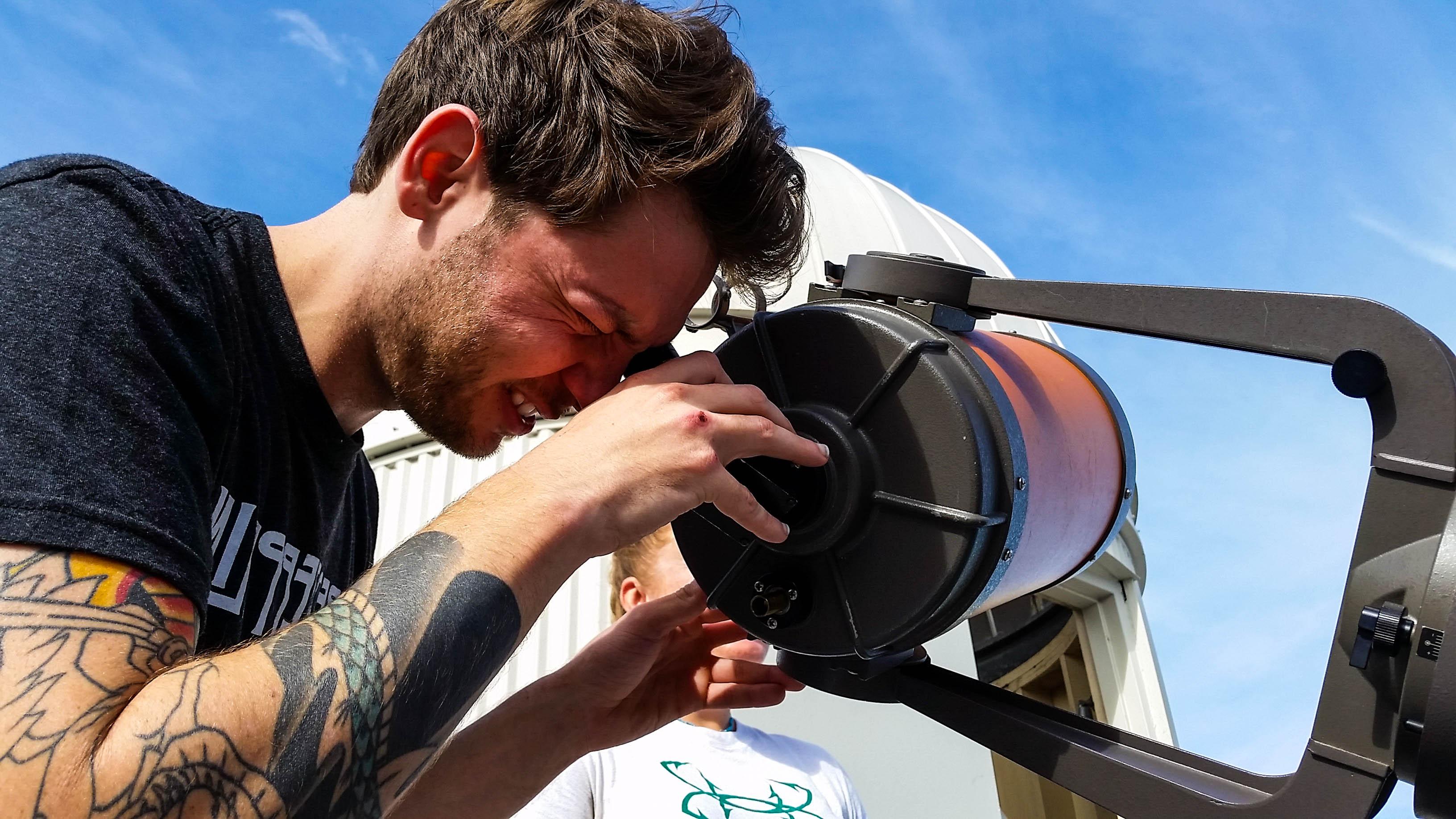 一个学生在看望远镜